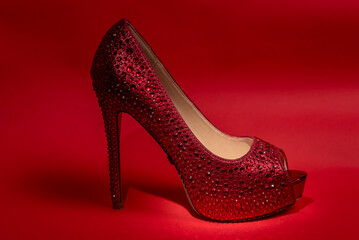 red women's shoes with high heels. red background.