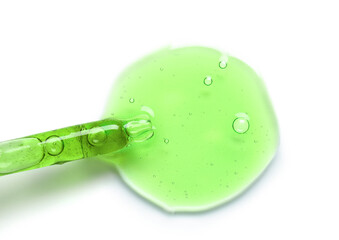 Glass dropper and sample of cosmetic serum on white background