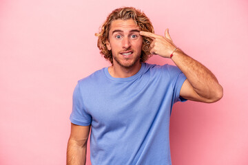 Young caucasian man isolated on pink background showing a disappointment gesture with forefinger.