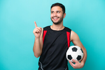 Young football player Brazilian man isolated on blue background pointing up a great idea