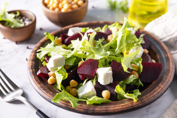 Healthy spring salad beet with spinach, cheese feta and chickpeas on a marble tabletop.
