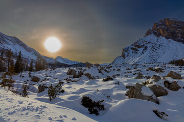 Snow covered mountains in the Fanes Alps with afternoon sun and halo