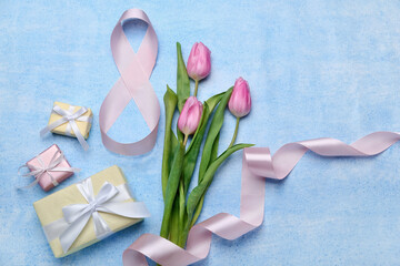 Composition with figure 8 made of ribbon, flowers and gift boxes for International Women's Day celebration on blue background