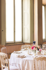 table setting for a wedding celebration with flowers in front of a window
