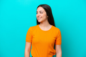 Obraz premium Young caucasian woman isolated on blue background looking side