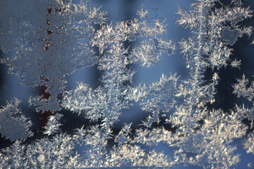 Frosty pattern on the glass of a window in a high-rise building. Winter frosts