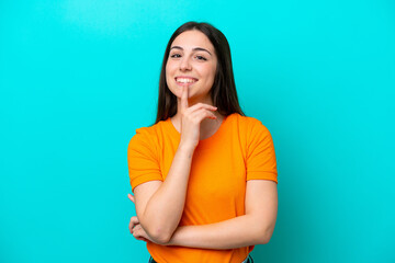 Young caucasian woman isolated on blue background showing a sign of silence gesture putting finger...