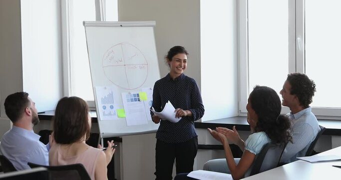Friendly young Indian female business trainer make speech for staff, finish training, employees applauding express gratitude for received knowledge skill, showing respect. Seminar, recognition concept