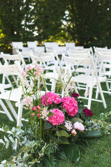 Fototapeta na wymiar Close up of wedding decoration bouquet with white chairs in a garden during the summer in Lombardy, Italy