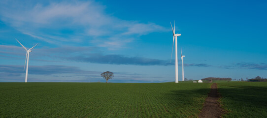 Two wind turbines generating renewable energy on a clear windy day