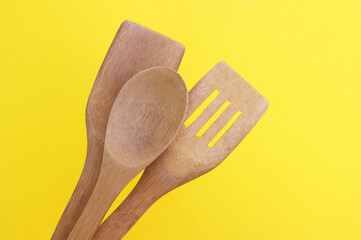 A set of bamboo dishes on a bright yellow background.