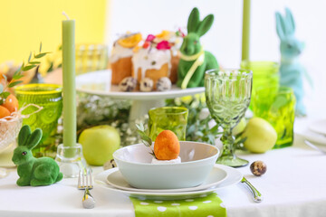 Dinnerware with Easter egg and eucalyptus branch on served table