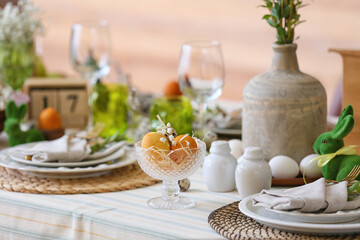 Bowl with Easter eggs and gypsophila flowers on served table, closeup