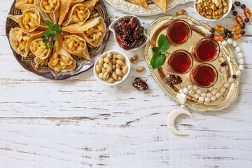 Ramadan kareem festive, fasting, halal food. Ramadan menu: assorted arabian pancake katayef and dates, pistachio. Top view flat lay. Copy space.