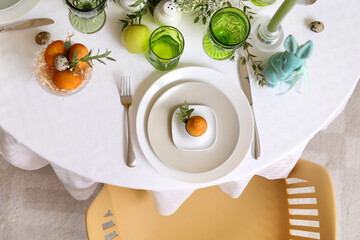 Plate with Easter egg and eucalyptus branch on served table
