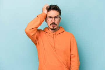 Young caucasian man isolated on blue background tired and very sleepy keeping hand on head.