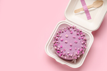 Plastic lunch box with tasty bento cake on pink background
