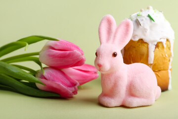 Cute Easter bunny, cake and flowers on color background
