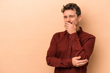 Obraz premium Young caucasian man isolated on beige background laughing happy, carefree, natural emotion.