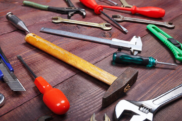 Variety of plumbing tools for repair work on wooden background.
