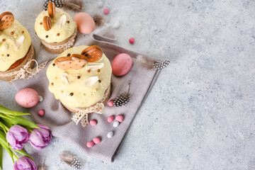 Composition with tasty Easter cakes, eggs and tulip flowers on light background