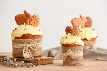 Delicious Easter cakes decorated with cookies on table