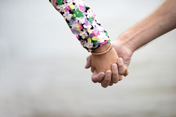 Close up of loving couple holding hands on a beach near the sea