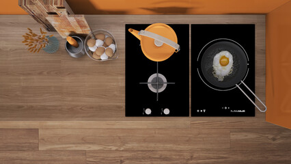 Orange and wooden kitchen close up, induction and gas hob with pot and fried egg in a pan. Vase with spikes, cutting boards. Top view, plan, above with copy space, interior design
