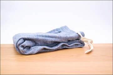 morbidi joggers in felpa di cotone melange con coulisse su una piano in legno e sfondo bianco