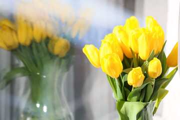 Bouquet of yellow tulip flowers near window, closeup