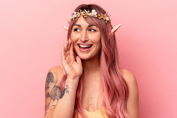 Young caucasian elf woman isolated on pink background shouting and holding palm near opened mouth.