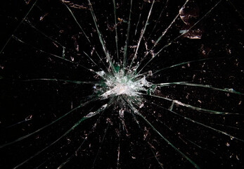 A broken glass on a black background, a big hole at the center and many shattered pieces around it....