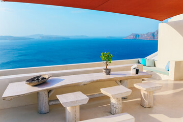 Wooden table and stools with beautiful sea view on terrace in Santorini