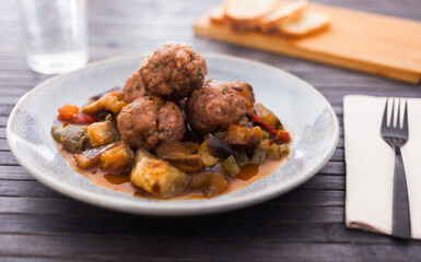 baked meatballs with stewed eggplant, zucchini, green peppers and tomatoes with haze in bowl