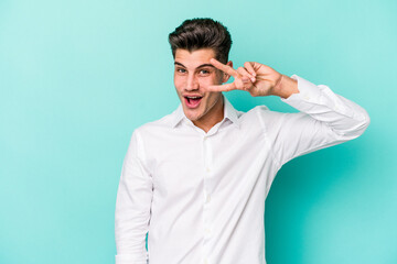 Young caucasian man isolated on blue background dancing and having fun.