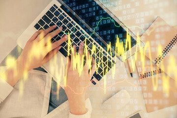 Double exposure of woman hands working on computer and forex graph hologram drawing. Top View....