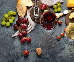 Red wine with appetizers on gray background.