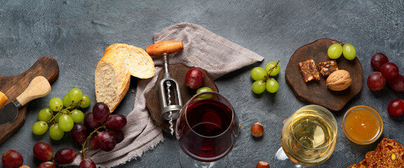 Red wine with appetizers on gray background.