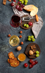 Red wine with appetizers on gray background.