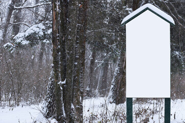 Bulletin Board, advertising, portable street stand poster with blank space for text, mock up in the winter forest, conservation, nature protection. information carrier. cold season, forest in the snow