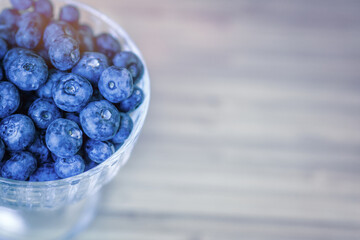 Blueberry berry dessert in a bowl on a light wooden background. Healthy food
