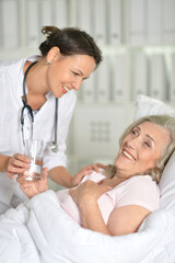 Obraz na płótnie Canvas Sick senior woman portrait in hospital with doctor