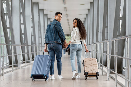 Romantic young middle eastern couple walking together in airport terminal