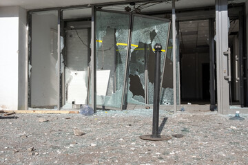 Destroyed automatic sliding glass doors in entrance of building due to vandalism. Looted shopping...