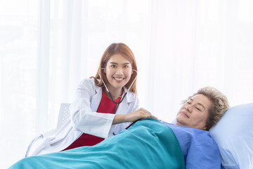 Obraz premium A young beautiful doctor is checking an old patient woman.