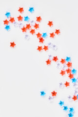 frame of blue, red and transparent stars on a white background. banner for the celebration of Independence Day on July 4th. copy space, top view, vertical frame