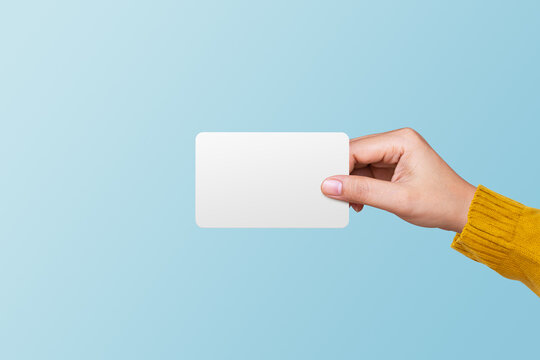 Woman holding blank white card on blue background. Business concept
