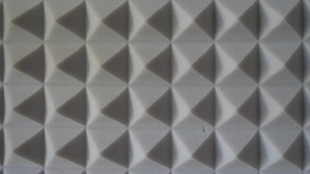 Pyramids of soundproof foam close-up. Noise suppression tool. Gray acoustic foam. Acoustic foam is an open celled foam used for acoustic treatment. It attenuates airborne sound waves.
