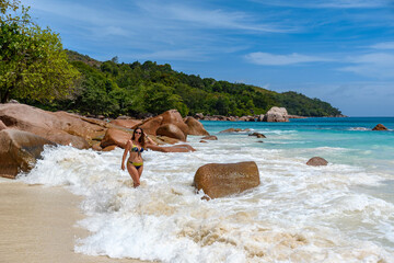 Adult woman wearing a bikini and posing at the Anse Lazio beach in Seychelles