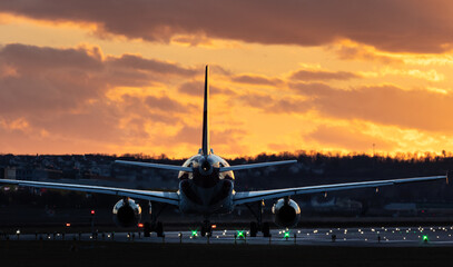 Aircraft ready for take off at Stuttgart Airport, red and green rundway lights, against golden...